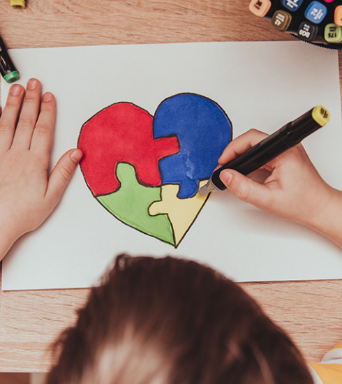 enfant en train de dessiné un coeur, découpé en 3 pièces de puzzle